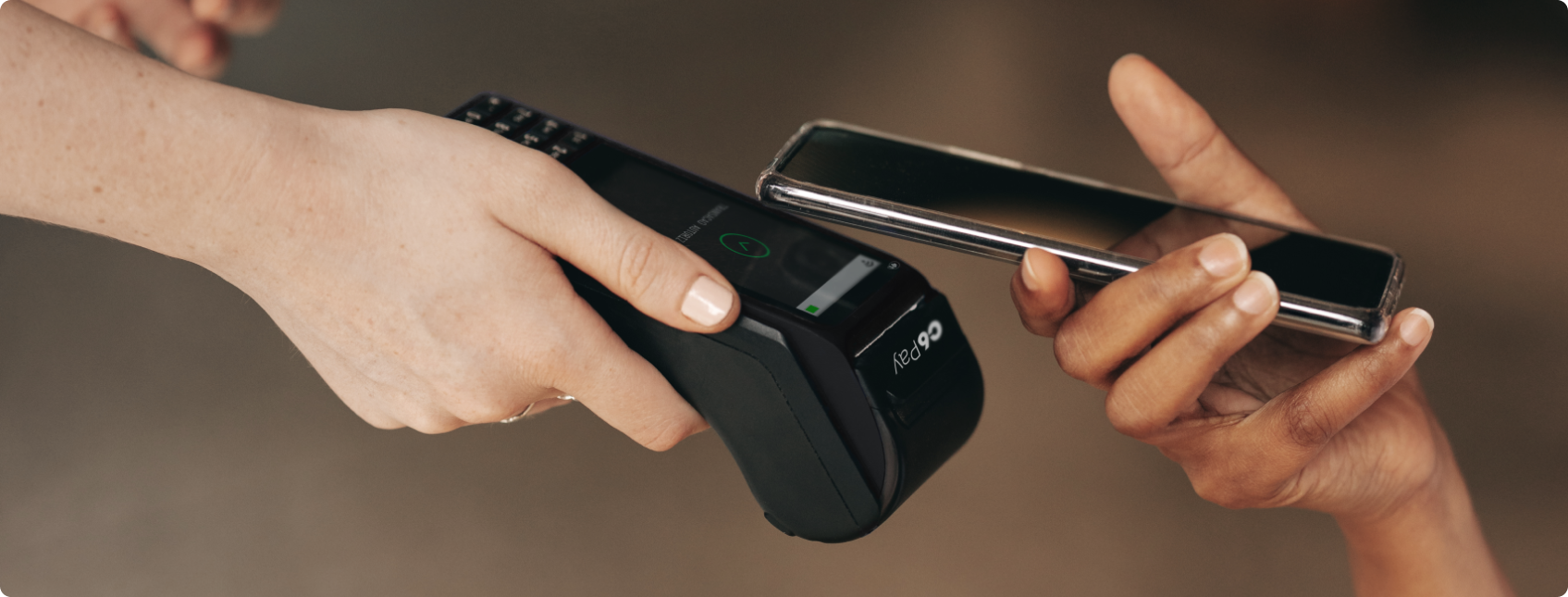 Pessoa realiza pagamento por aproximação com celular em maquininha.