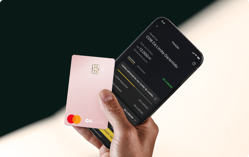 Mão segura um Cartão C6 Pink e um celular com o app C6 Bank.
