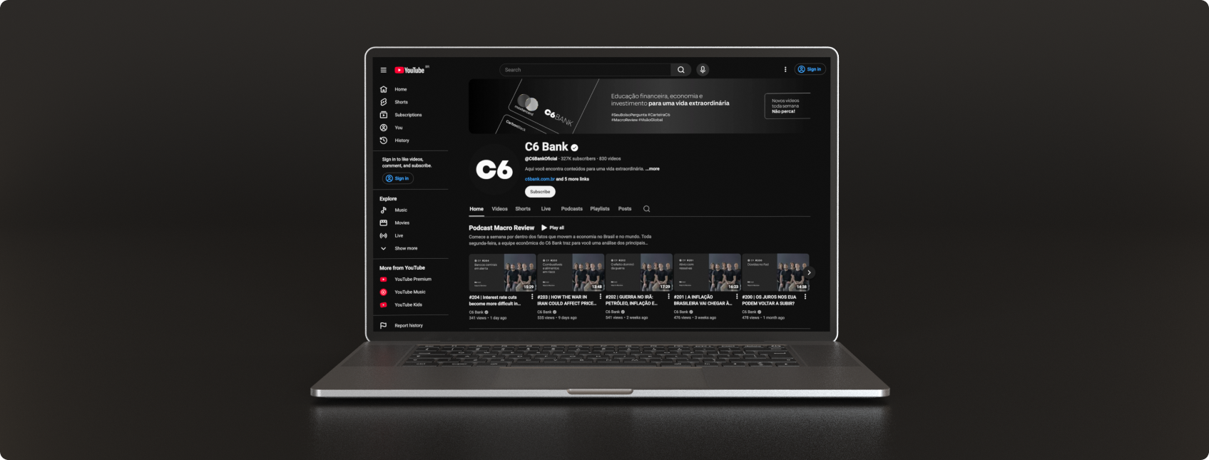 Notebook mostra o canal do C6 Bank no YouTube, com banner, menu lateral e vídeos do podcast “Macro Review” em destaque.